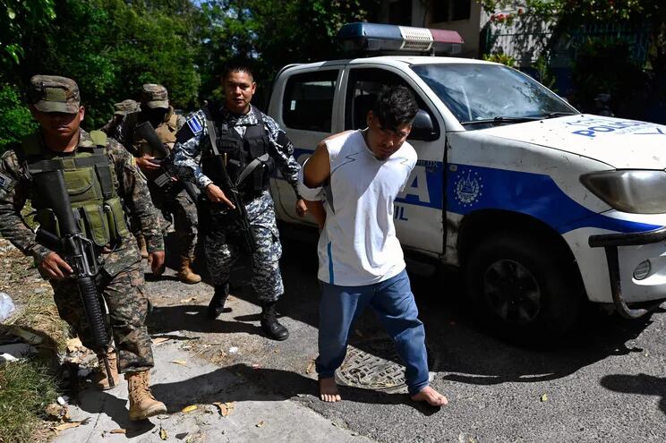 Policías y soldados escoltan a personas capturadas durante una operación contra pandilleros en Soyapango, El Salvador.