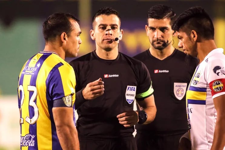 El árbitro Derlis López en el sorteo previo al partido en Luque con los capitanes, Juan Núñez (Luqueño) y Marcos Riveros.