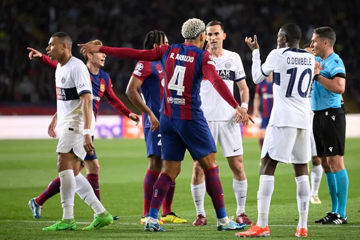 El uruguayo Ronald Araújo (4), jugador del Barcelona, protesta al árbitro por la tarjeta roja que recibió en el partido frente al París Saint-Germain por la vuelta de los cuartos de final de la Champions League en el estadio Olímpico Lluis Companys, en Barcelona, España.