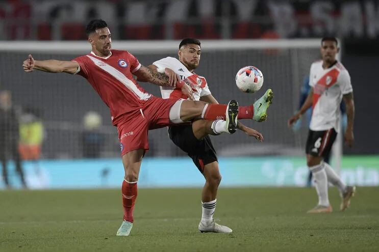 El paraguayo Gabriel Ávalos (i), de Argentinos Juniors, disputa el balón con el chileno Paulo Díaz, de River Plate, durante un reciente partido por la Liga argentina.
