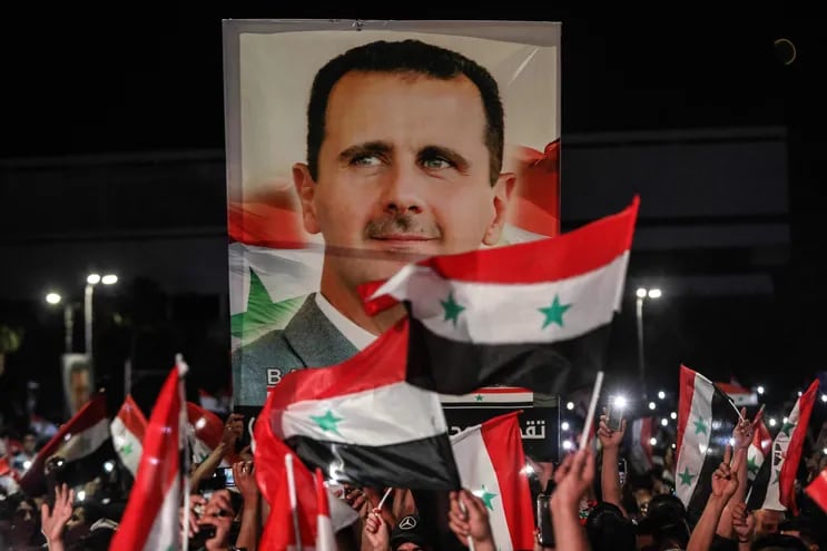 Ciudadanos sirios celebran portando un retrato del presidente Bashar al Asad, este jueves en Damasco.