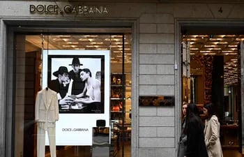 La gente pasa por la boutique Dolce & Gabbana en Via Monte Napoleone, una famosa calle comercial de lujo en Milán.