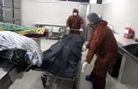 Trabajadores mueven una camilla con un cuerpo en la morgue del Hospital Pampa de la Isla, en Santa Cruz (Bolivia). Antes de la pandemia una morgue en Bolivia recibía unos tres cuerpos sin vida a la semana, pero ahora llega a acumular hasta treinta, teniéndolos que dejar algunos en el suelo.