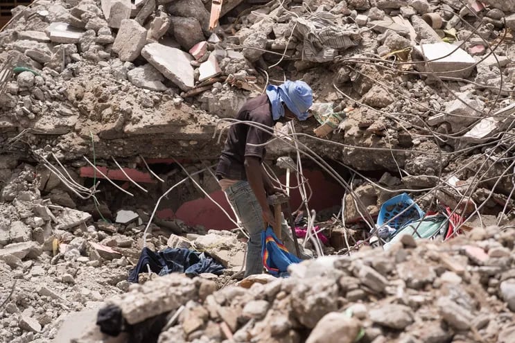 Un hombre camina sobre los escombros de una edificación en búsqueda de víctimas o sobrevivientes luego del terremoto del pasado 14 de agosto, en Les Cayes.