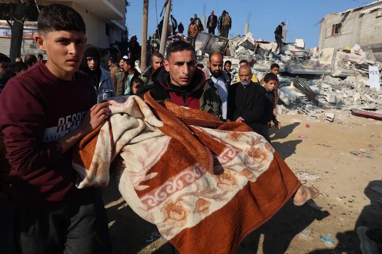 El cuerpo de un niño es rescatado este lunes de entre los escombros de una casa destruida en un bombardeo israelí en Jan Yunis, en el sur de la Franja de Gaza.