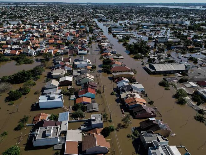 Aerial view of a flooded area of Canoas, a municipality north of Porto Alegre, Brazil, taken on May 7, 2024, after torrential rains devastated parts of the southern state of Rio Grande do Sul. Since the unprecedented deluge started last week, at least 90 people have died, 131 are missing and more than 150,000 were ejected from their homes by floods and mudslides in Rio Grande do Sul State, authorities said. (Photo by Nelson ALMEIDA / AFP)