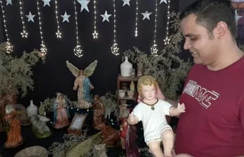 El sacerdote redentorista Juan Núñez sostiene en sus manos la imagen del Niño Jesús, que será puesto en el pesebre en la Nochebuena.