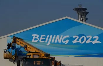 Trabajadores instalan un banner en el Parque Olímpico de Pekín.