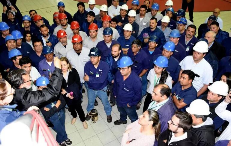 El jefe paraguayo del departamento Técnico de Yacyretá, Ing. Leopoldo Melo (de campera negra) conversa con los trabajadores que no pudieron iniciar las tareas de adecuación en la central.