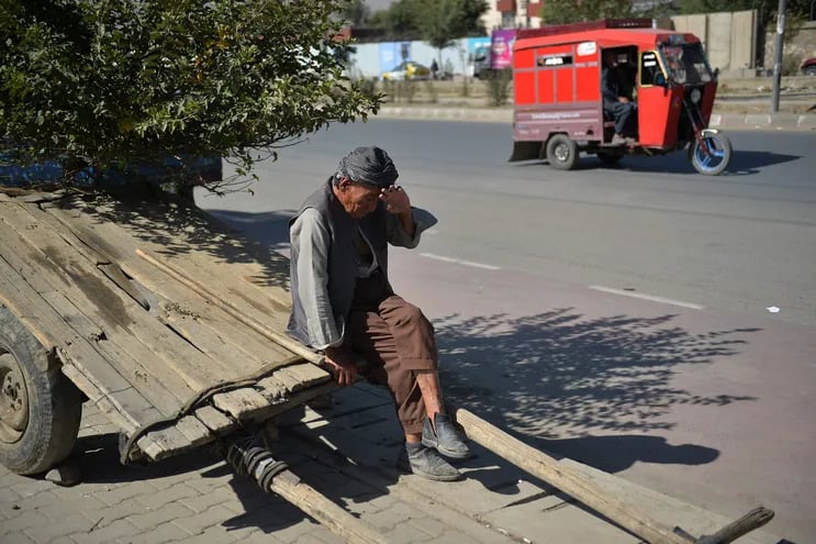 Un trabajador afgano con un carro descansa a la espera de clientes en Kabul, este domingo.