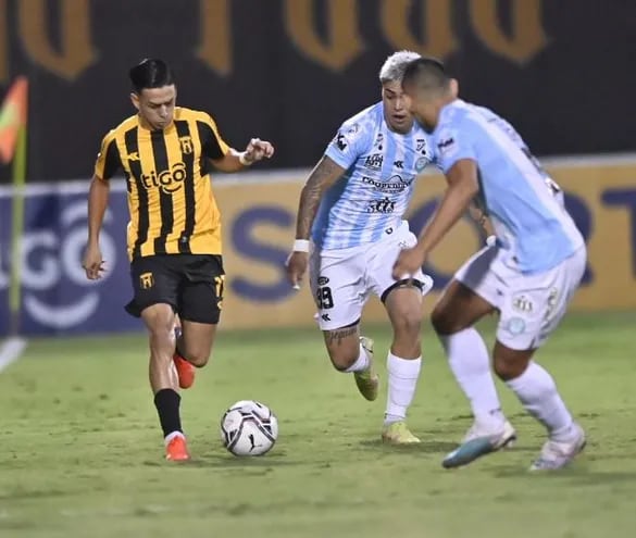 Matías Segovia trata de llevarse el balón con la marca de dos jugadores de Guaireña