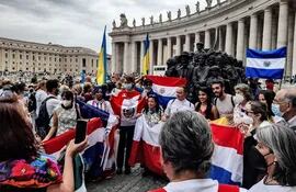 Comunidad latinoamericana junto a un monumento dedicado al Migrante en la Plaza de San Pedro. Banderas de distintos países, entre ellas una de Paraguay. (EFE)