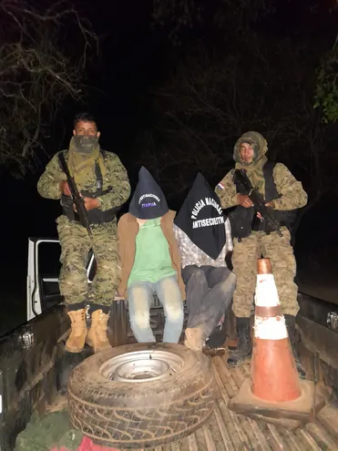 Efectivos policiales fuertemente armados custodian a Estanislao Insfrán y R. R. D. B., supuestos integrantes del UPP capturados en San Pedro del Paraná.