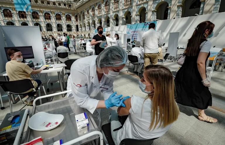 Moscow (Russian Federation), 06/07/2021.- A woman receives a shot of Russia's Sputnik V vaccine against COVID-19 disease at a vaccination center in Gostinny Dvor, a huge exhibition place in Moscow in Moscow, Russia, 06 July 2021. Moscow being the epicenter of the new outbreak of the infectious by the new Delta variant. Moscow authorities imposed a ban to serve people without QR-codes confirming vaccination against Covid-19 at public caterings, including people recovering from coronavirus Covid-19 disease within six months before the visit, or negative PCR test taken no earlier than 72 hours before the visit. (Rusia, Moscú) EFE/EPA/YURI KOCHETKOV
