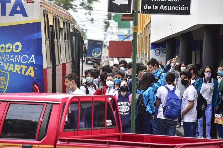 Estudiantes esperando transporte público en el centro de Asunción.