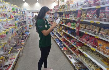 Una alumna de la Universidad Nacional del Este en la recolección de datos en un supermercado de Ciudad del Este.