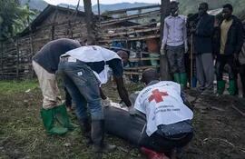 Voluntarios de la Cruz Roja envuelven cuerpos en mantas en una zona de inundaciones en Nyamukubi, República Democrática del Congo.