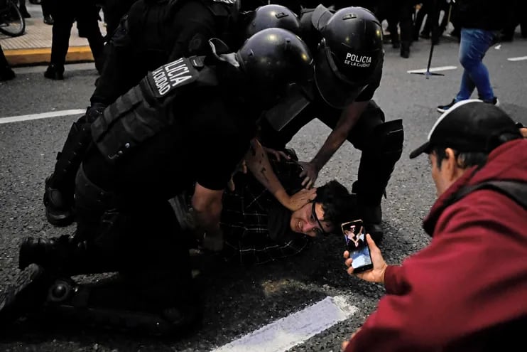 Un manifestante es reducido por agentes antidisturbios durante una protesta contra los recortes del gobierno de Javier Milei a la cultura.