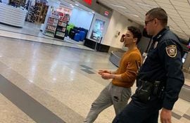 Junio Gaspar Caballero, momento en el que era trasladado por un oficial de seguridad en el Aeropuerto Silvio Pettirossi, el domingo.