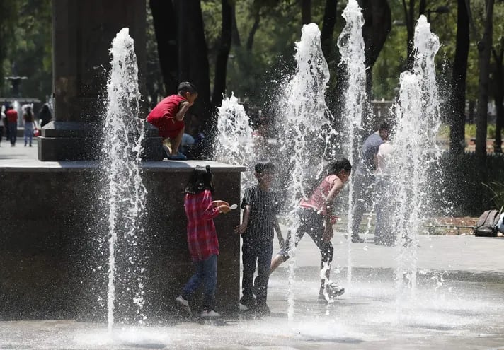 Niños juegan con el agua durante un día caluroso, en Ciudad de México (México).