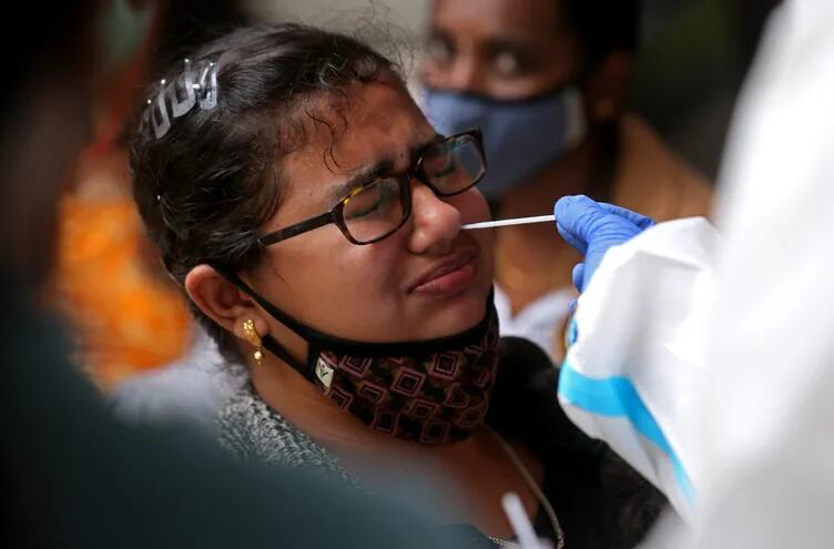 Un trabajador sanitario toma una muestra en busca de COVID-19 en India.