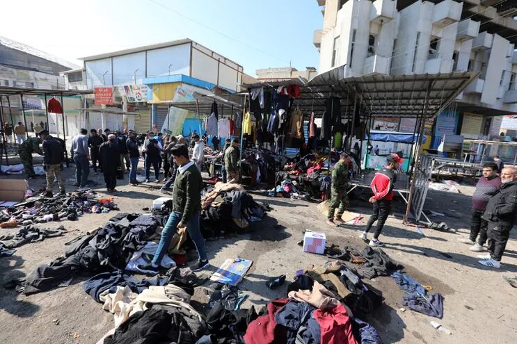 Iraquíes limpian el sitio de la explosión en el mercado de Bagdad.