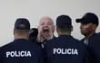 El expresidente de Panamá (c) aparece esposado y custodiado por varios agentes panameños. Afronta una causa que podría enviarlo a prisión por unos 12 años.