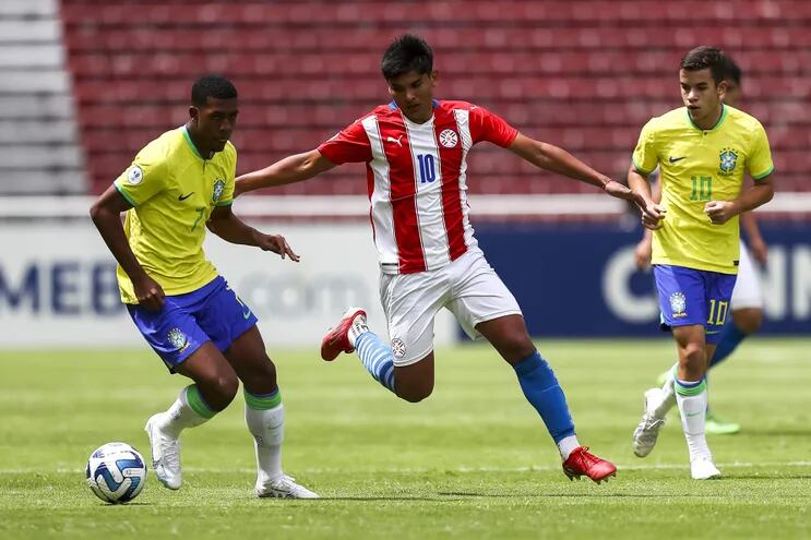 El jugador de Brasil Rayan Simplicio (i) disputa el balón con Paulo Riveros (c) de Paraguay hoy, en un partido del Sudamericano Sub-17 en el estadio Rodrigo Paz en Quito (Ecuador).