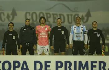 Los árbitros y los capitanes de Tacuary y Guaireña en la foto previa al partido por el fútbol paraguayo.
