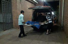 Funcionarios de una funeraria retiran el cuerpo de la mujer de la morgue del Hospital Regional de Concepción.