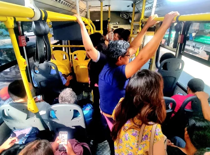 Pasajeros viajan abarrotados en un bus de transporte público.