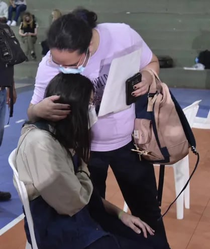Una mujer besa a su hija en la jornada de vacunación contra el COVID-19 en el llamado "Día A", para niños y jóvenes de entre 12 a 17 años en la sede de la Secretaría Nacional de Deportes.