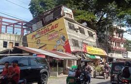 Una fotografía proporcionada por la Oficina del Congresista Ching Bernos (OCCB) muestra a automovilistas maniobrando junto a un edificio dañado tras un terremoto en Bangued, provincia de Abra, Filipinas, el 27 de julio de 2022.