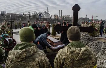 Familiares, amigos y compañeros de Dmytro y Kirilo, dos de los tres soldados ucranianos muertos en combate, participan este miércoles en su entierro en el Cementerio de Lychakiv en Leópolis. E