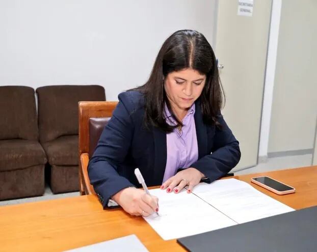 Mónica Seifart firma  el documento que avlala su postulación para la fiscalía general.