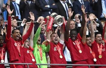 Jordan Henderson, capitán del Liverpool, levanta el trofeo de la FA Cup rodeado de sus compañeros.