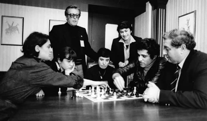Olimpiada de Lucerna 1982, Gufeld mira a Kasparov analizando con Chiburdanidze. Están presentes Ioseliani, Gaprindashvili y Alexandria. De pie, Gipslis (Foto via ChessBase).
