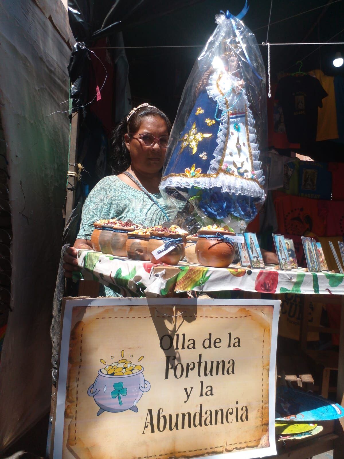 Elena Acosta, muestra las ollitas de la suerte junto a una imagen de la Virgen de Caacupé, que cuesta 200.000 guaraníes.