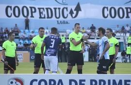 Los jugadores de Sportivo Ameliano y Guaireña saludan a los árbitros en la previa del partido por el fútbol paraguayo 2022 en el Parque del Guairá de la ciudad de Villarrica.