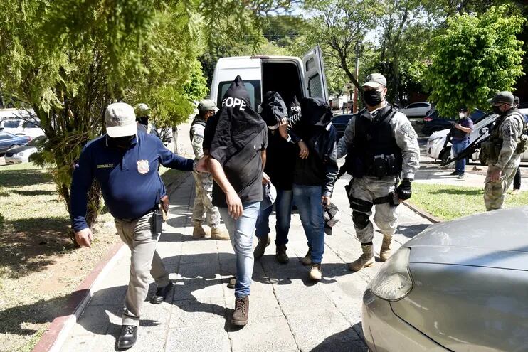 El comisario principal Sebastián Ramírez (i) entrega  a los detenidos en el departamento Judicial de la Policía, en Asunción. Fue ayer.