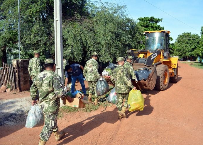 Efectivos de la 4ª División de Infantería depositaron basura en un tractor para llevar los desperdicios  hasta un camión volquete.