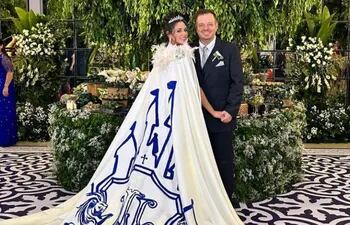Natasha Zacarías con un capa en el vestido con una estampado de castillo e iniciales de la pareja. A lado está su esposo Luis Octavio López.