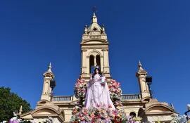 La sagrada imagen de la Virgen del Rosario. De fondo  sobresale la cúpula del templo parroquial.