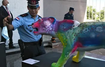 Un oficial de Policía se toma una selfie con "Gato", el yaguarete de tamaño real intervenido por la artista Fiorella Bittar.