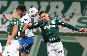 Gustavo Gómez (d), de Palmeiras, salta en procura del balón ante un jugador de Universidad Católica.