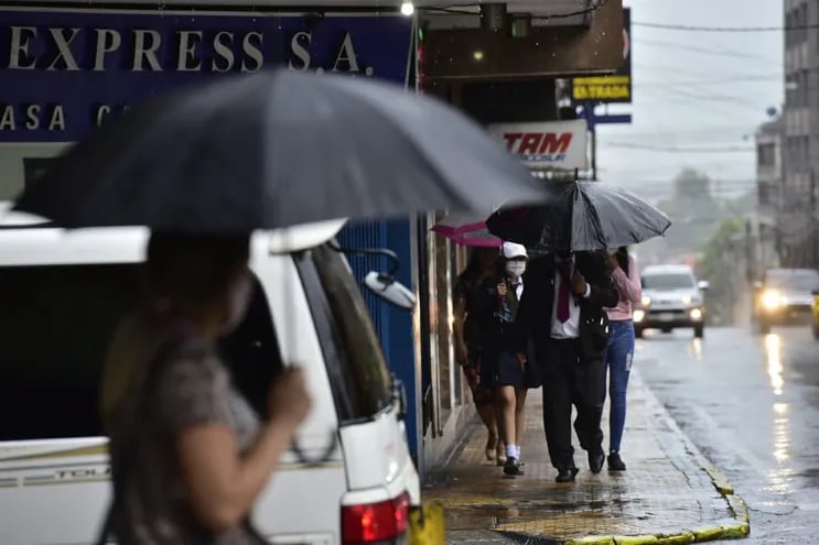 Algunos ciudadanos, además de utilizar paraguas, debieron refugiarse bajo les techos de los locales para progerse de las lluvias.