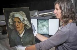 Lesley Stevenson exhibe la pintura "Retrato de una campesina", junto a una imagen en rayos x de la imagen donde estaría el autorretrato del pintor Vincent Van Gogh.