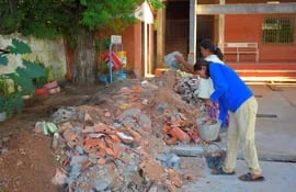Las trabajadoras de la escuela Manuel Ortiz Guerrero, tratando de limpiar los escombros que quedaron en el patio de la escuela a raíz de la obra inconclusa.