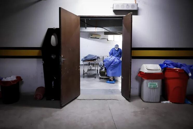 Personal de una funeraria se prepara para realizar el levantamiento del cadáver de un trabajador sanitario fallecido por covid-19, en la morgue del Hospital de Clínicas, en San Lorenzo (Imagen referencial).