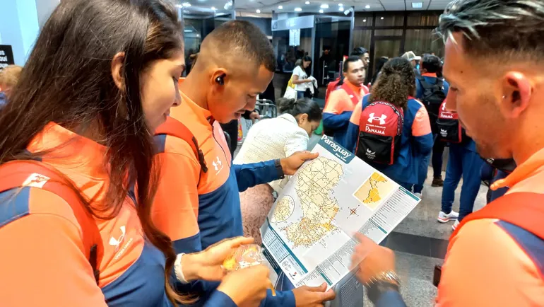 Parte de la delegación de deportistas revisando un mapa del Paraguay.